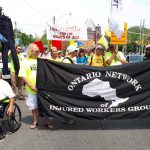 Injured Workers macrh behind ONIWG banner